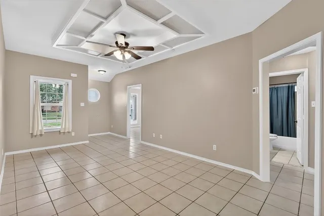 an empty room with fan and windows