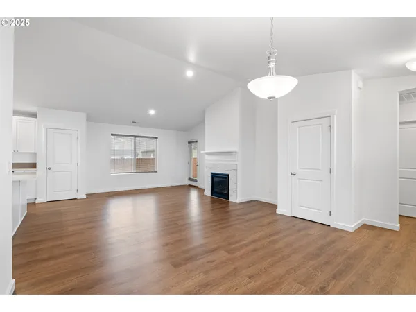 a view of empty room with wooden floor and fireplace