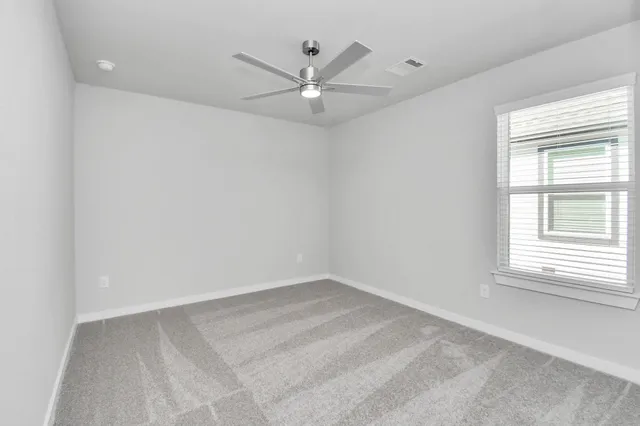 an empty room with a window and a fan