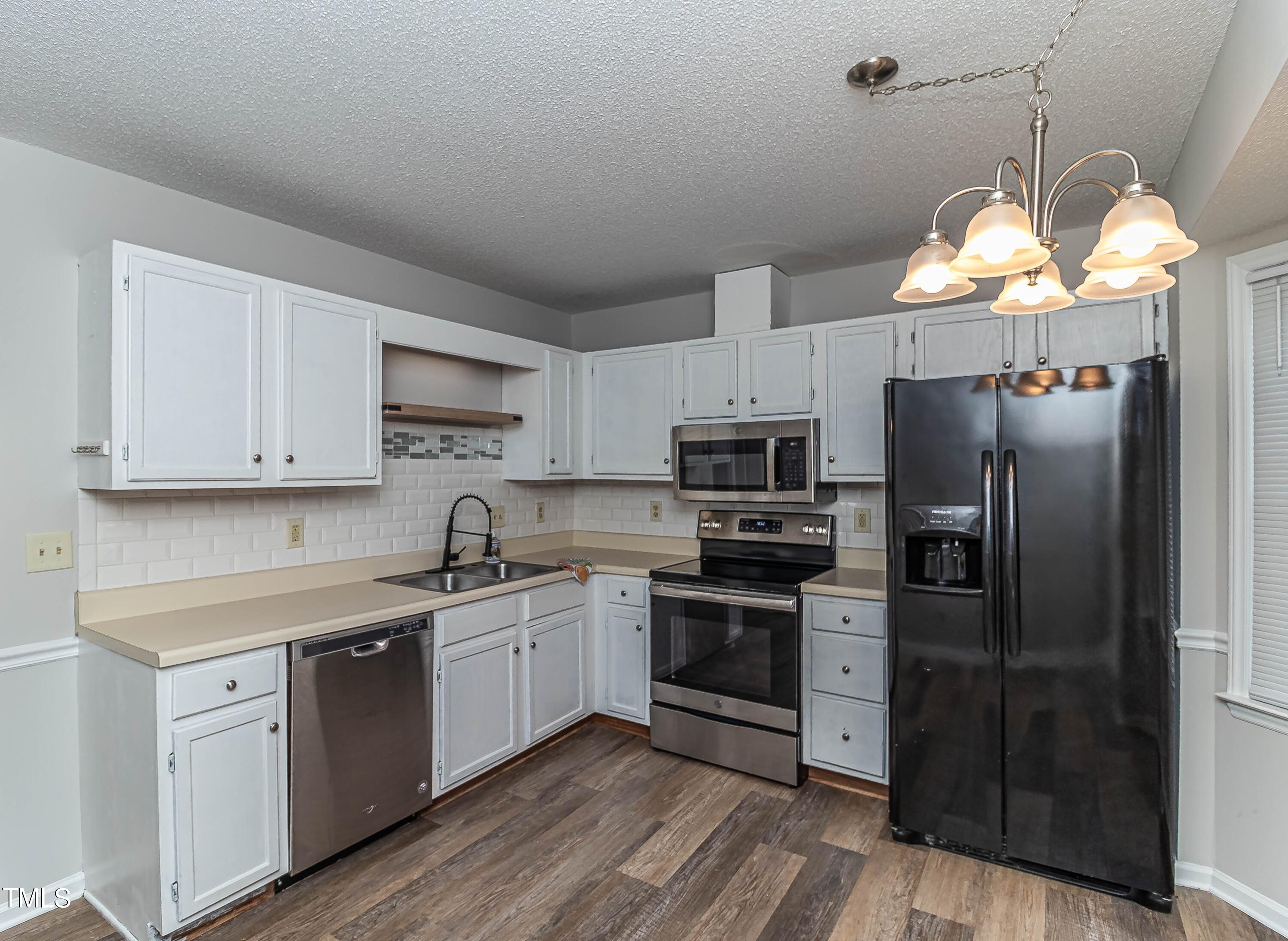 410 Barbour Road Smithfield, NC 27577 - Photo 5 of 16 a kitchen with stainless steel appliances granite countertop a refrigerator a sink dishwasher a stove and white cabinets with wooden floor