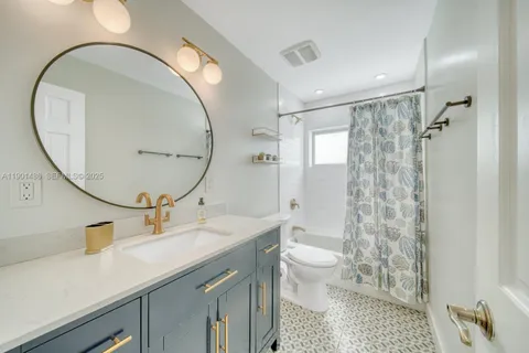 a spacious bathroom with a sink a toilet a mirror and a shower