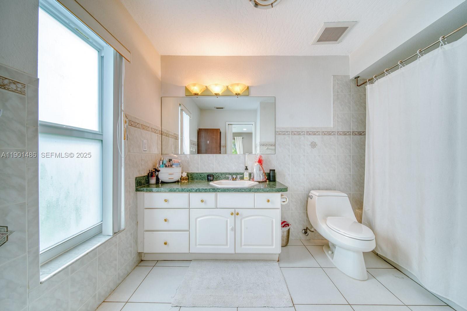 10860 Southwest 124th Road Miami, FL 33176 - Photo 21 of 47 a spacious bathroom with a granite countertop toilet a sink and a mirror