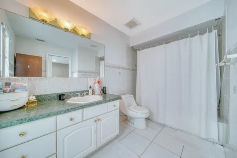 a bathroom with a granite countertop sink mirror vanity and toilet