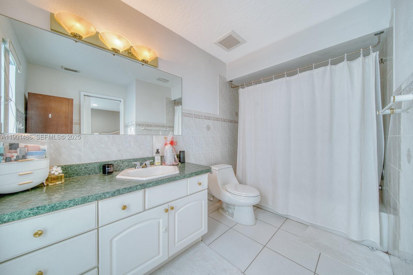 10860 Southwest 124th Road Miami, FL 33176 - Photo 22 of 47 a bathroom with a granite countertop sink mirror vanity and toilet