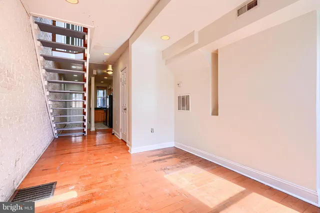a view of empty room with wooden floor and cabinet