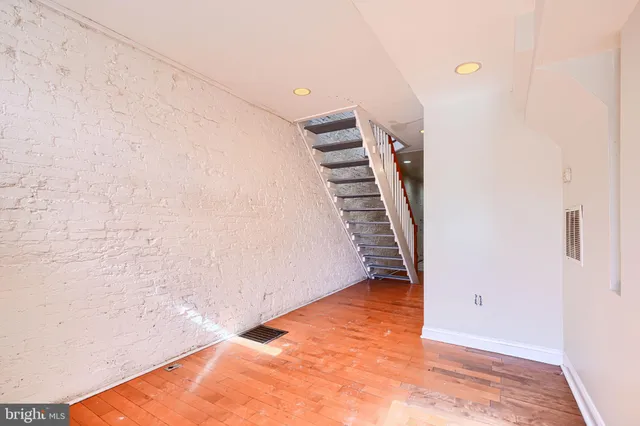 a view of an empty room with wooden floor