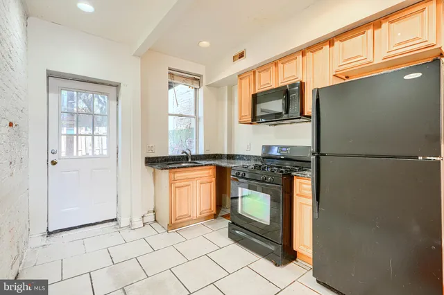 a kitchen with stainless steel appliances granite countertop a refrigerator stove and sink