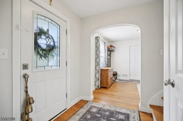 a view of a hallway with wooden floor and a livingroom