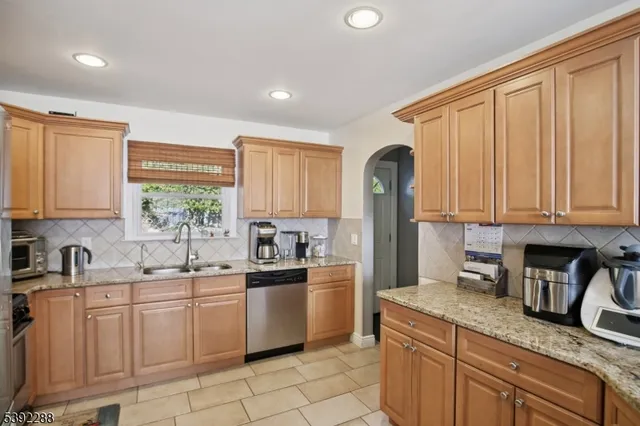 a kitchen with granite countertop a sink stainless steel appliances and cabinets