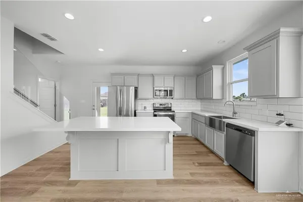 a large kitchen with stainless steel appliances lots of counter space and a sink