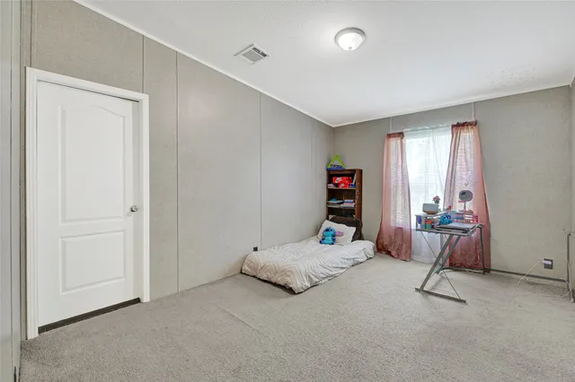 a bedroom with a bed a standing and a large window