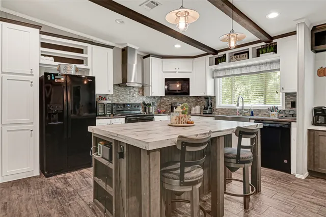 a kitchen with kitchen island granite countertop a sink appliances cabinets and furniture