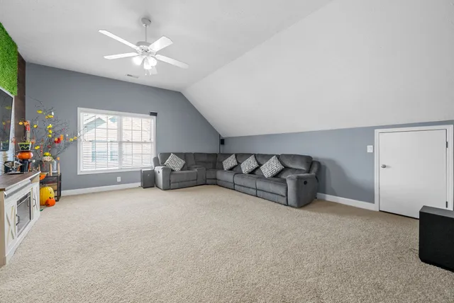 a living room with furniture and a large window with garden view