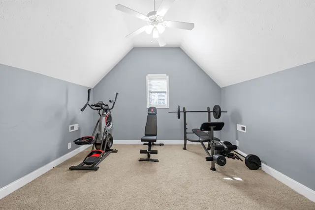 a view of a house with large trees and plants