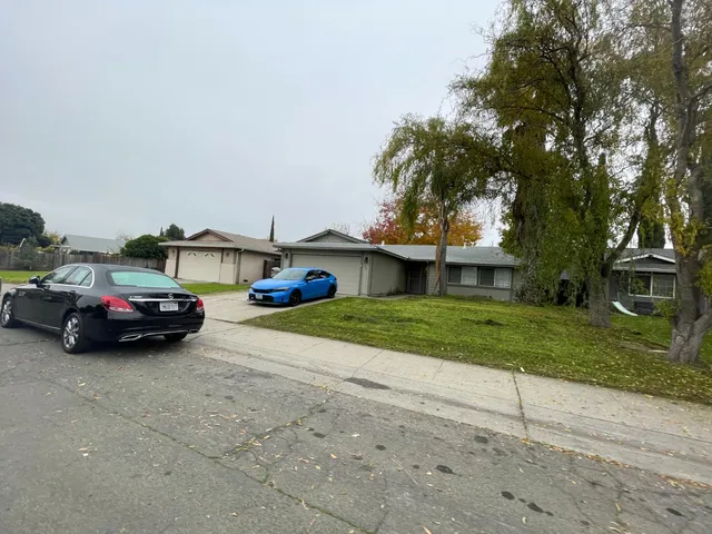 a view of a car parked in front of a house with a yard