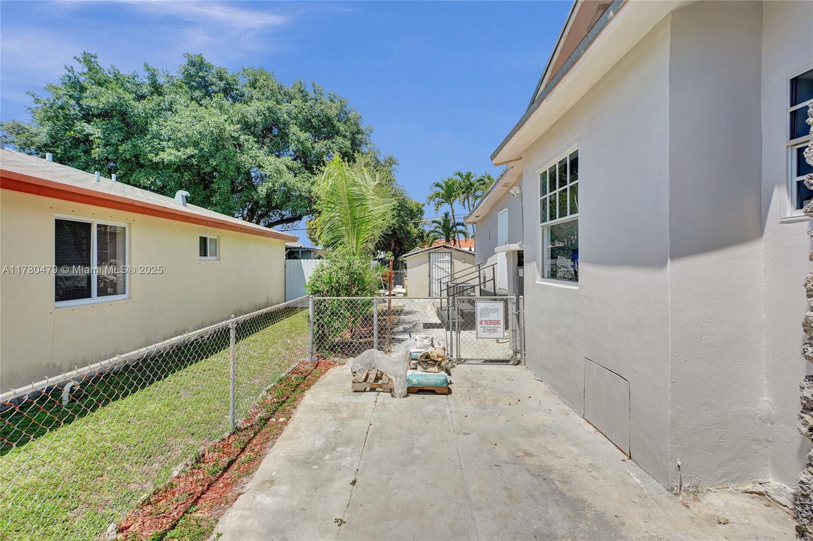213 Northwest 34th Terrace Miami, FL 33127 - Photo 7 of 18 a view of a patio with table and chairs with wooden fence and plants