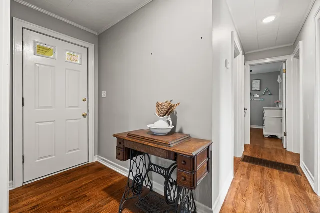 a view of a hallway with wooden floor and furniture