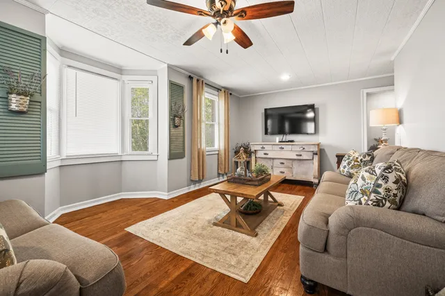 a living room with furniture a flat screen tv and a large window