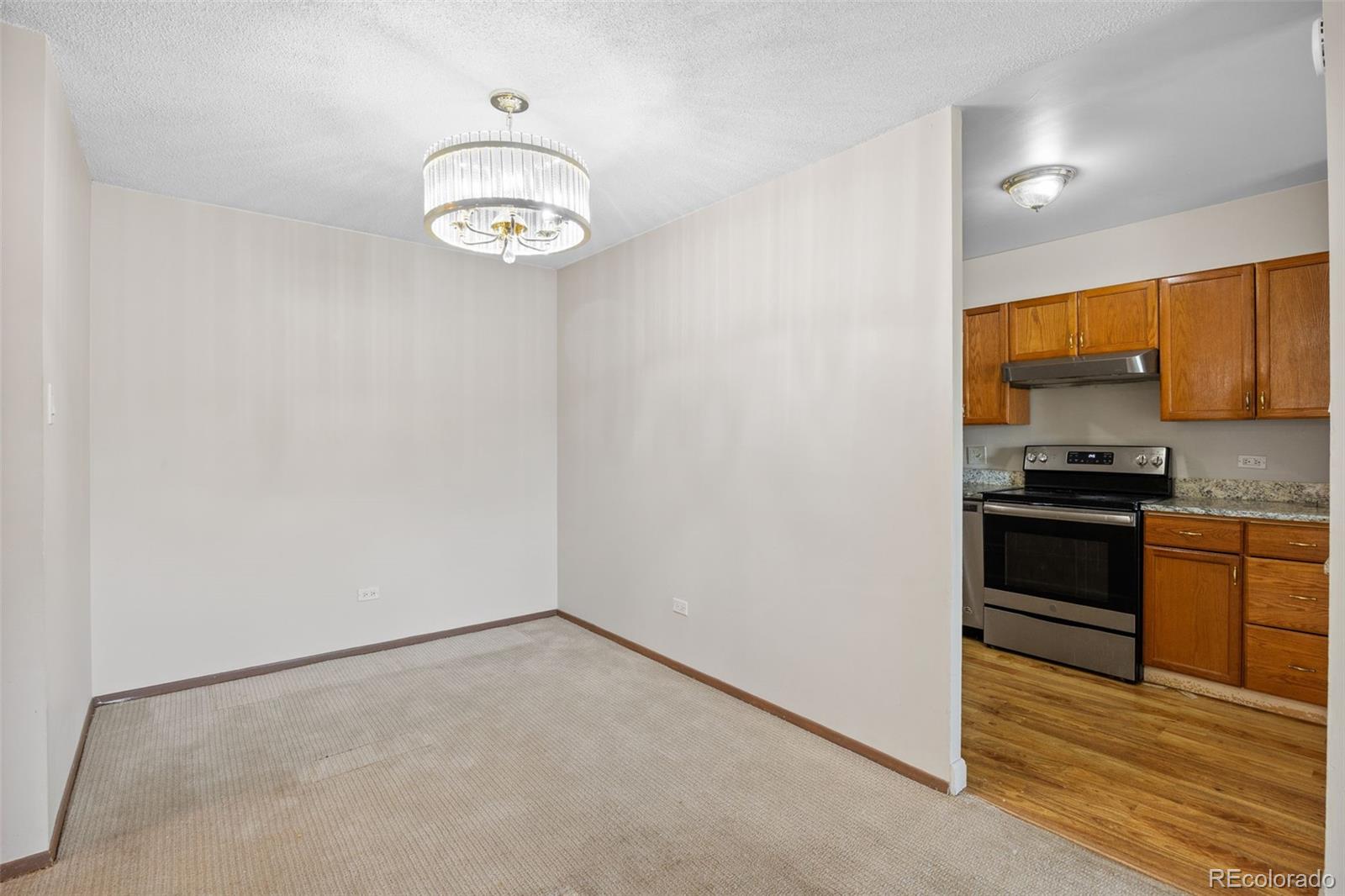 650 South Alton Way, Unit 3B Denver, CO 80247 - Photo 6 of 19 a kitchen with a refrigerator and a stove top oven