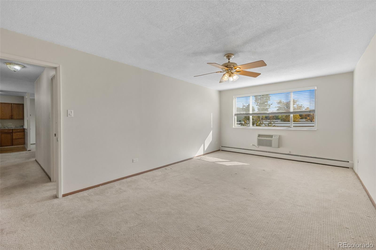 650 South Alton Way, Unit 3B Denver, CO 80247 - Photo 10 of 19 an empty room with chandelier fan and windows