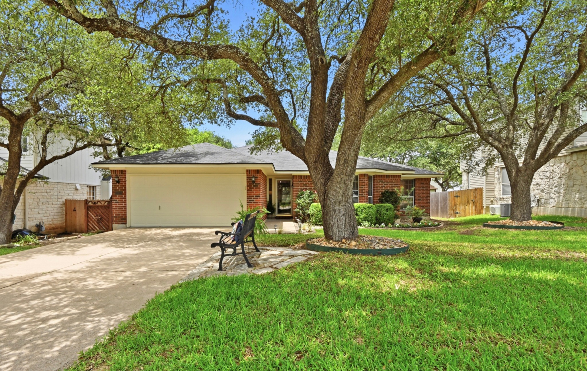 1409 Knoll Ridge Drive Cedar Park, TX 78613 - Photo 3 of 30 Mature trees shade this charming brick home with an attached garage, offering comfortable suburban living.