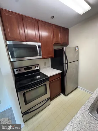 a metallic refrigerator freezer sitting inside of a kitchen
