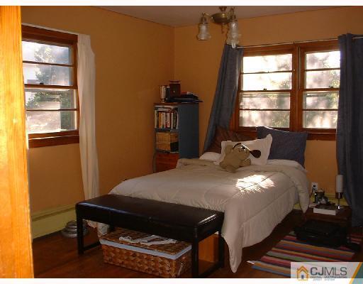 115 McFarlane Road Colonia, NJ 07067 - Photo 4 of 8 a bed sitting in a bedroom next to a window
