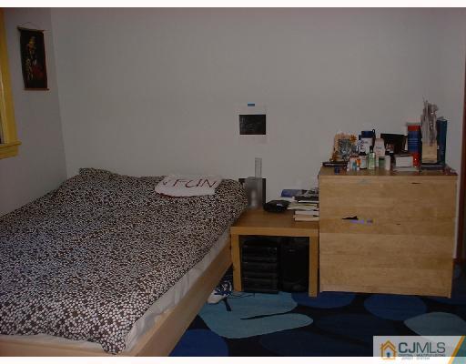 115 McFarlane Road Colonia, NJ 07067 - Photo 6 of 8 a bed sitting in a bedroom next to a lamp