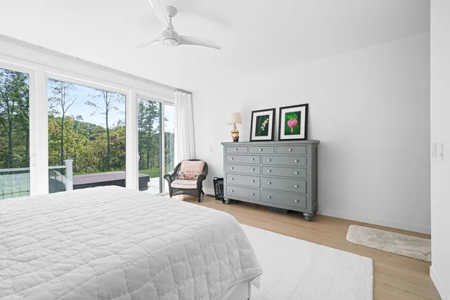 a bedroom with a bed and a lamp on dresser