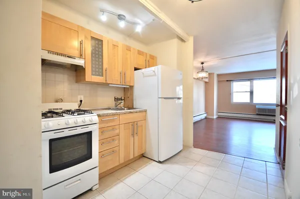 a kitchen with a stove top oven and refrigerator
