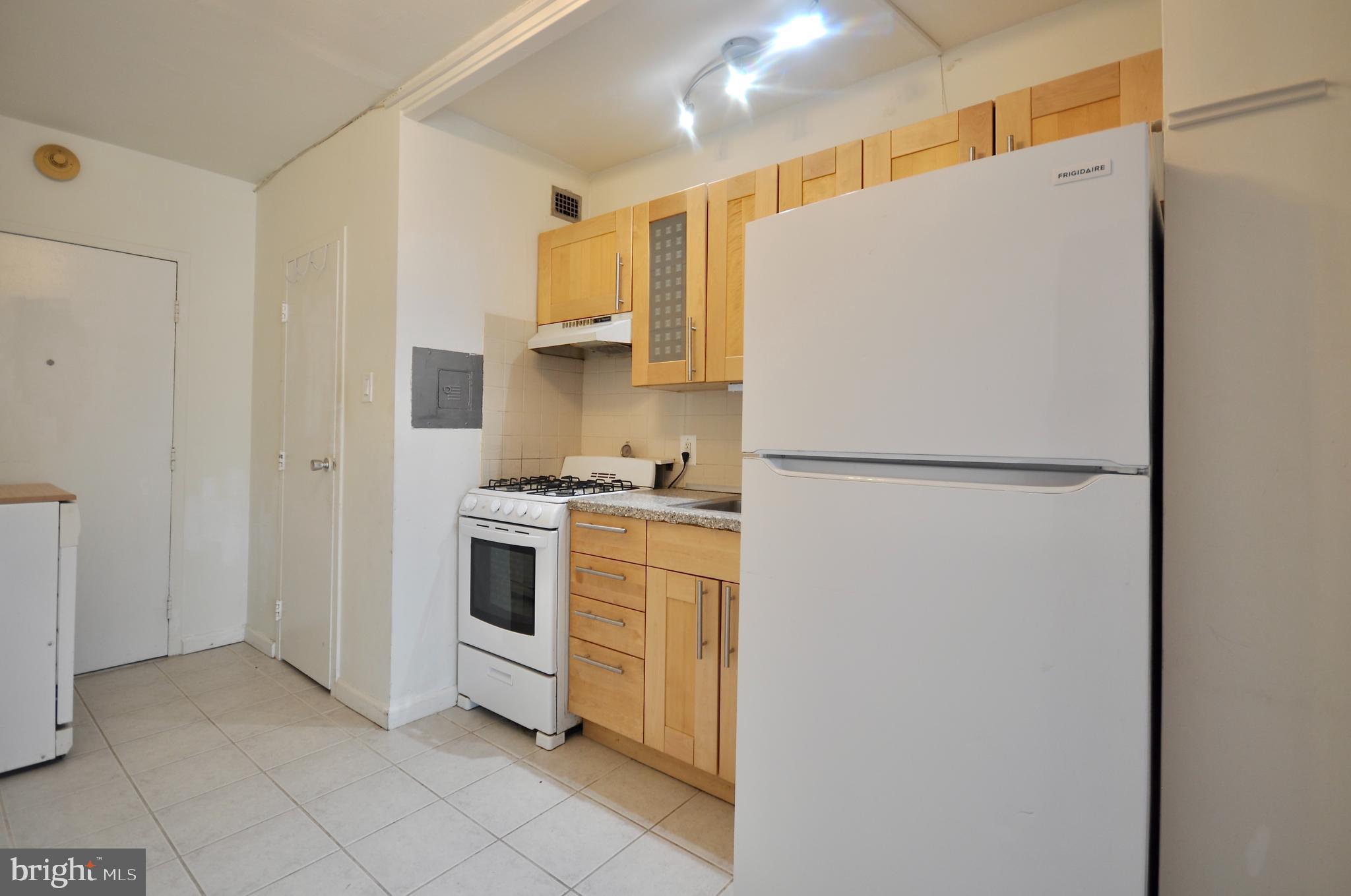 7900 Old York Road, Unit 608B Elkins Park, PA 19027 - Photo 14 of 19 a kitchen with a refrigerator a stove top oven and cabinets