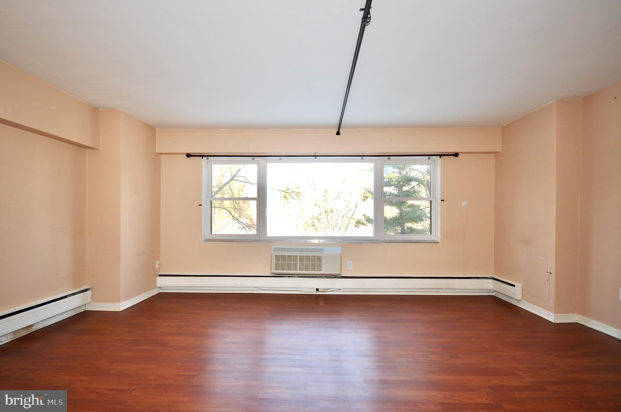 7900 Old York Road, Unit 608B Elkins Park, PA 19027 - Photo 3 of 19 an empty room with wooden floor and windows