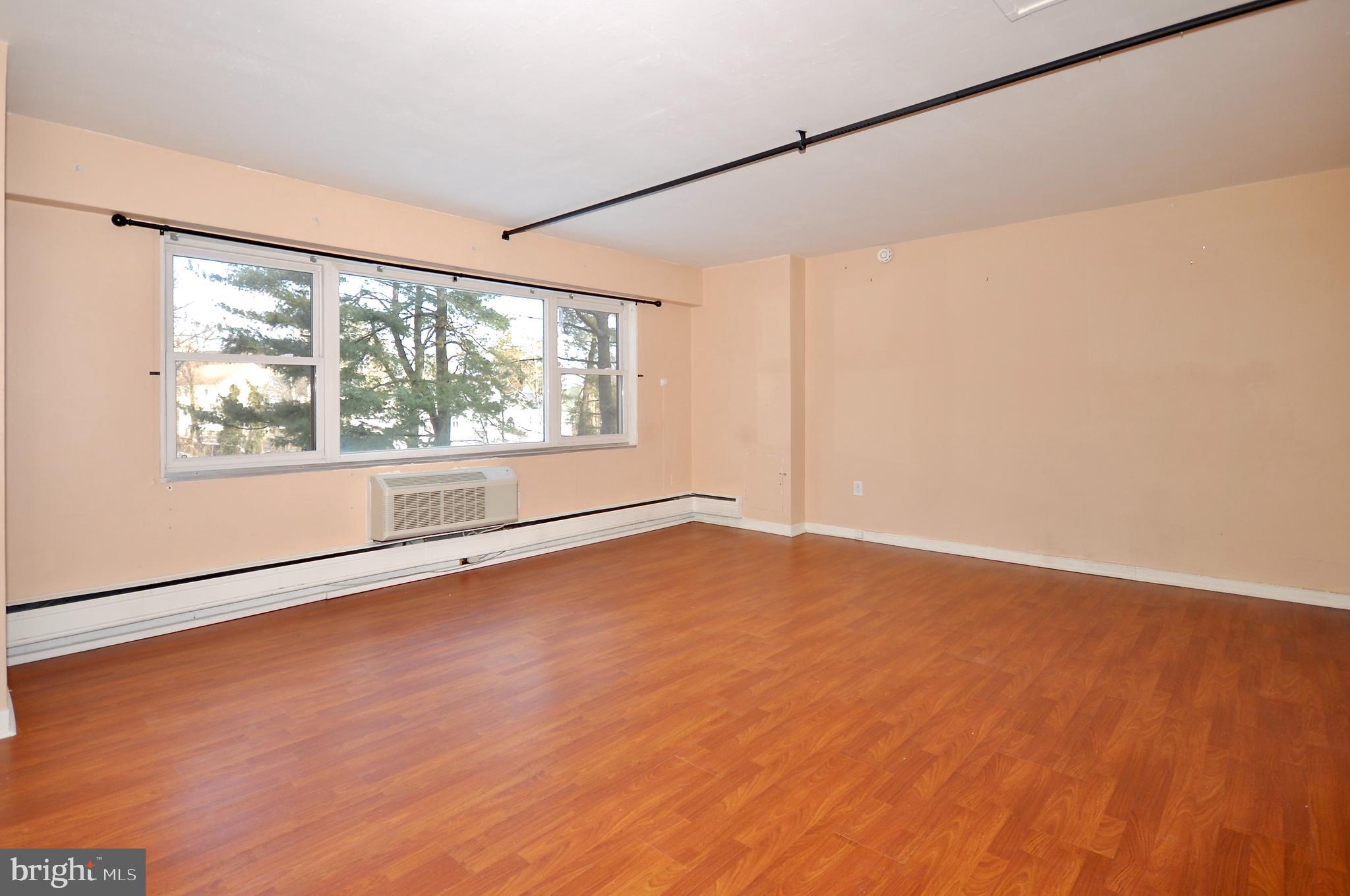7900 Old York Road, Unit 608B Elkins Park, PA 19027 - Photo 4 of 19 an empty room with wooden floor and windows