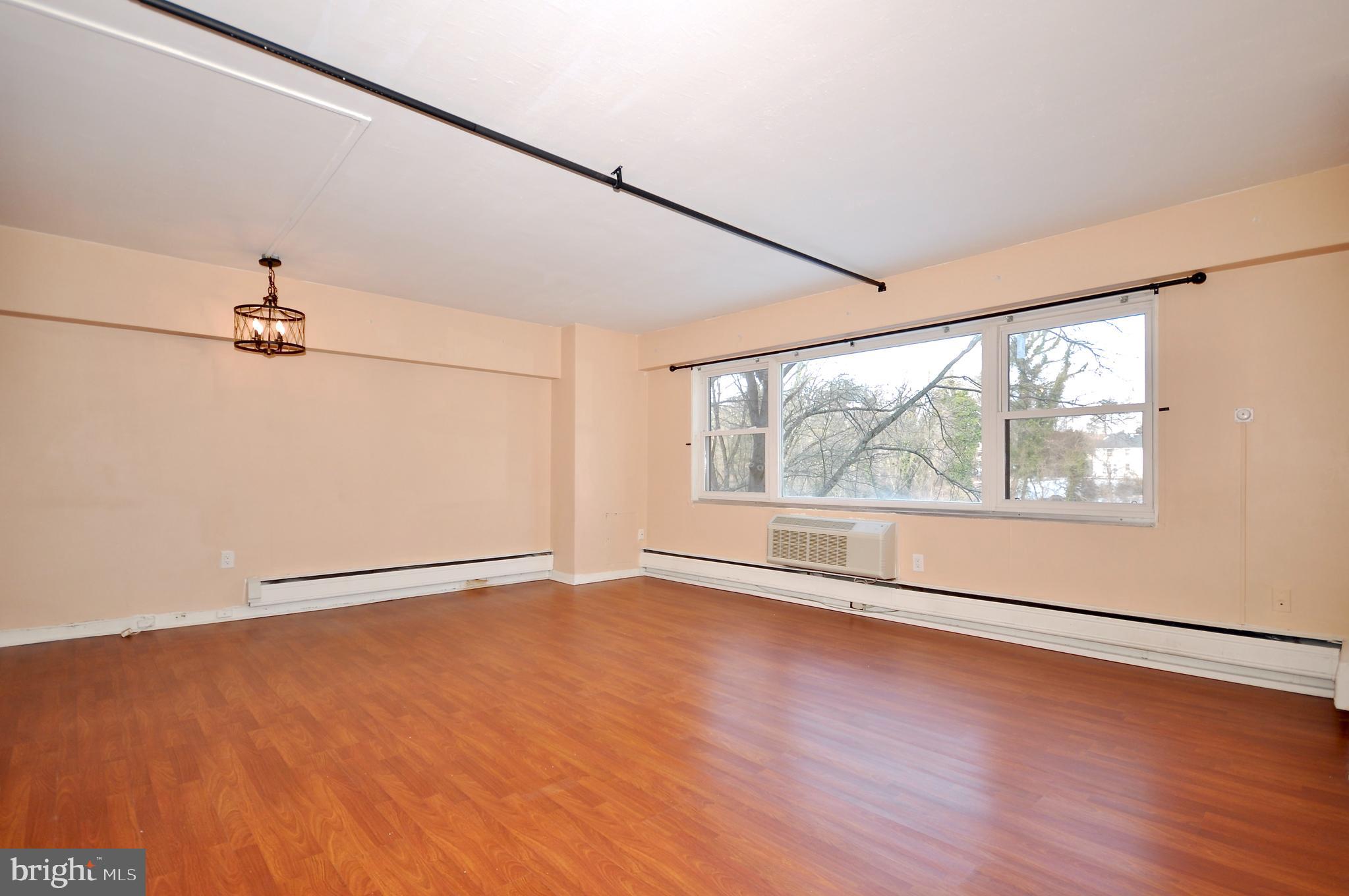 7900 Old York Road, Unit 608B Elkins Park, PA 19027 - Photo 6 of 19 an empty room with wooden floor and windows