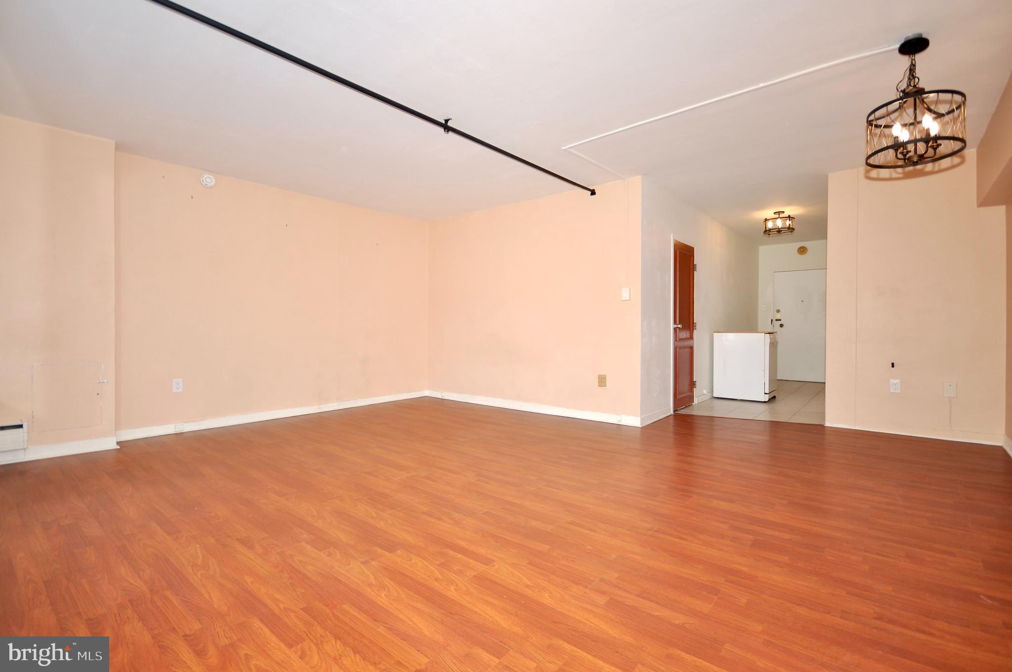 7900 Old York Road, Unit 608B Elkins Park, PA 19027 - Photo 7 of 19 a view of an empty room with wooden floor and a window