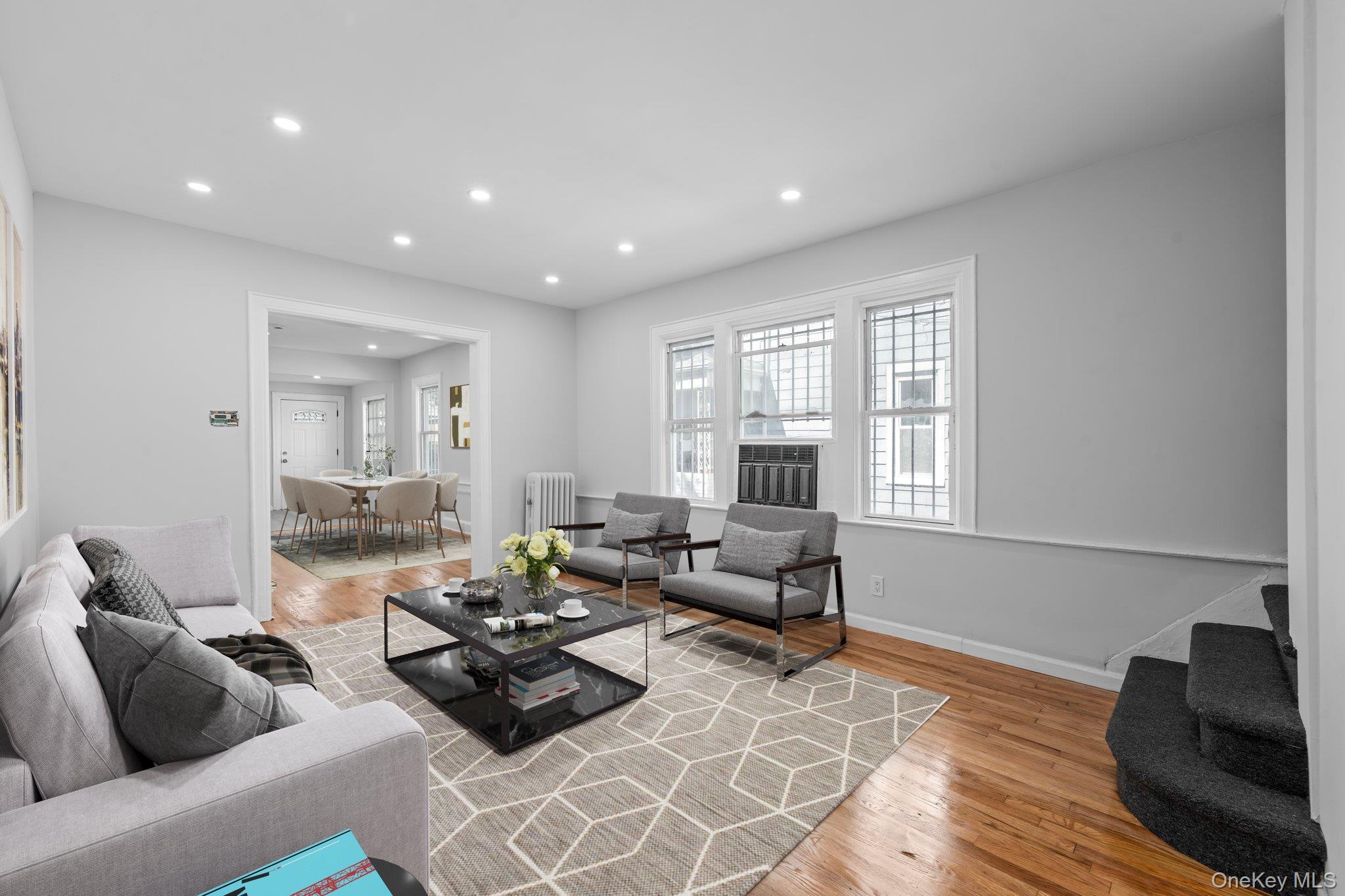 Living area with light wood-type flooring, recessed lighting, and radiator