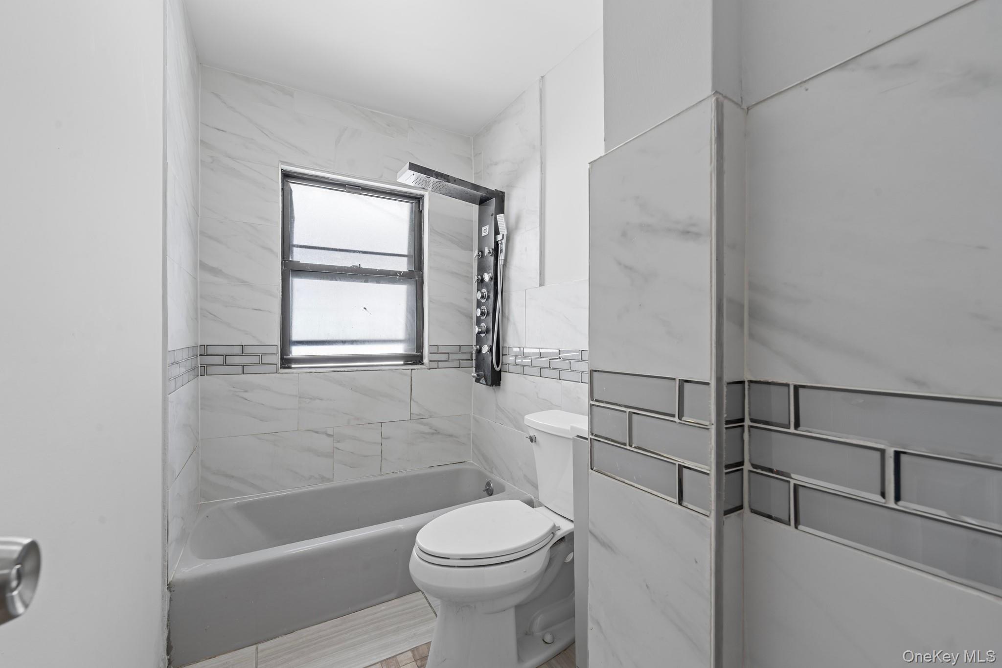 1069 East 35th Street Brooklyn, NY 11210 - Photo 11 of 16 Full bath with shower / bathtub combination and tile walls