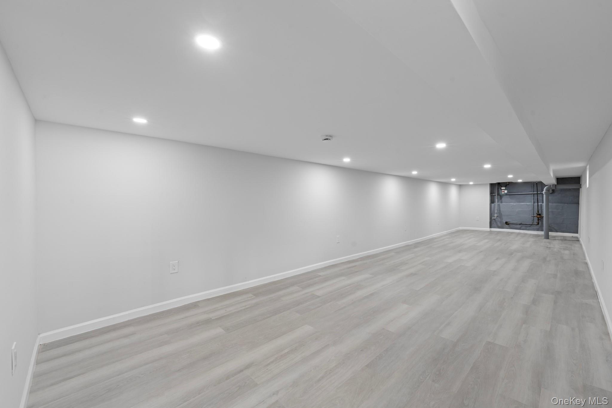 1069 East 35th Street Brooklyn, NY 11210 - Photo 13 of 16 Finished basement with light wood-style flooring and recessed lighting