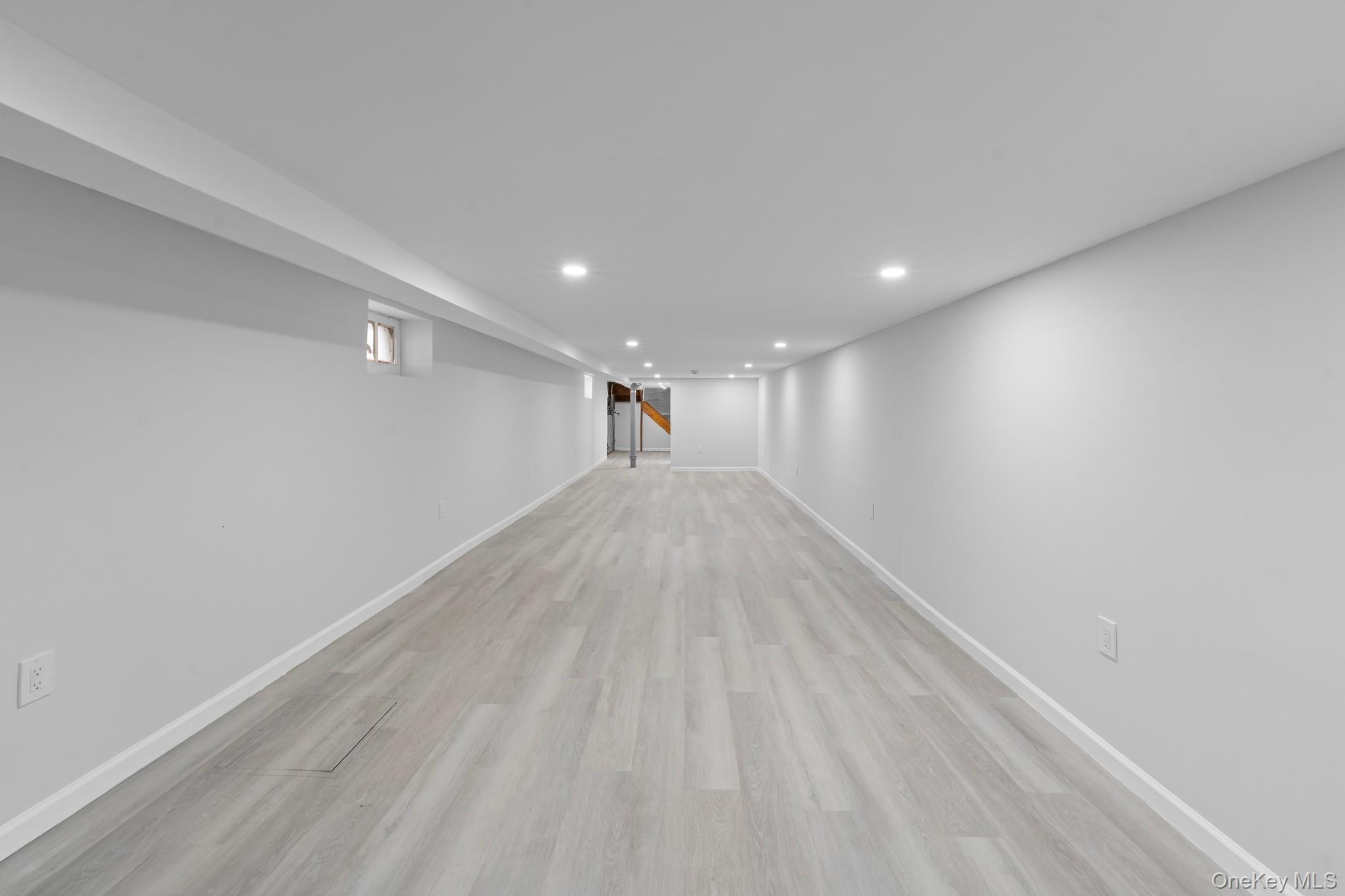 1069 East 35th Street Brooklyn, NY 11210 - Photo 14 of 16 Finished basement with light wood-type flooring and recessed lighting