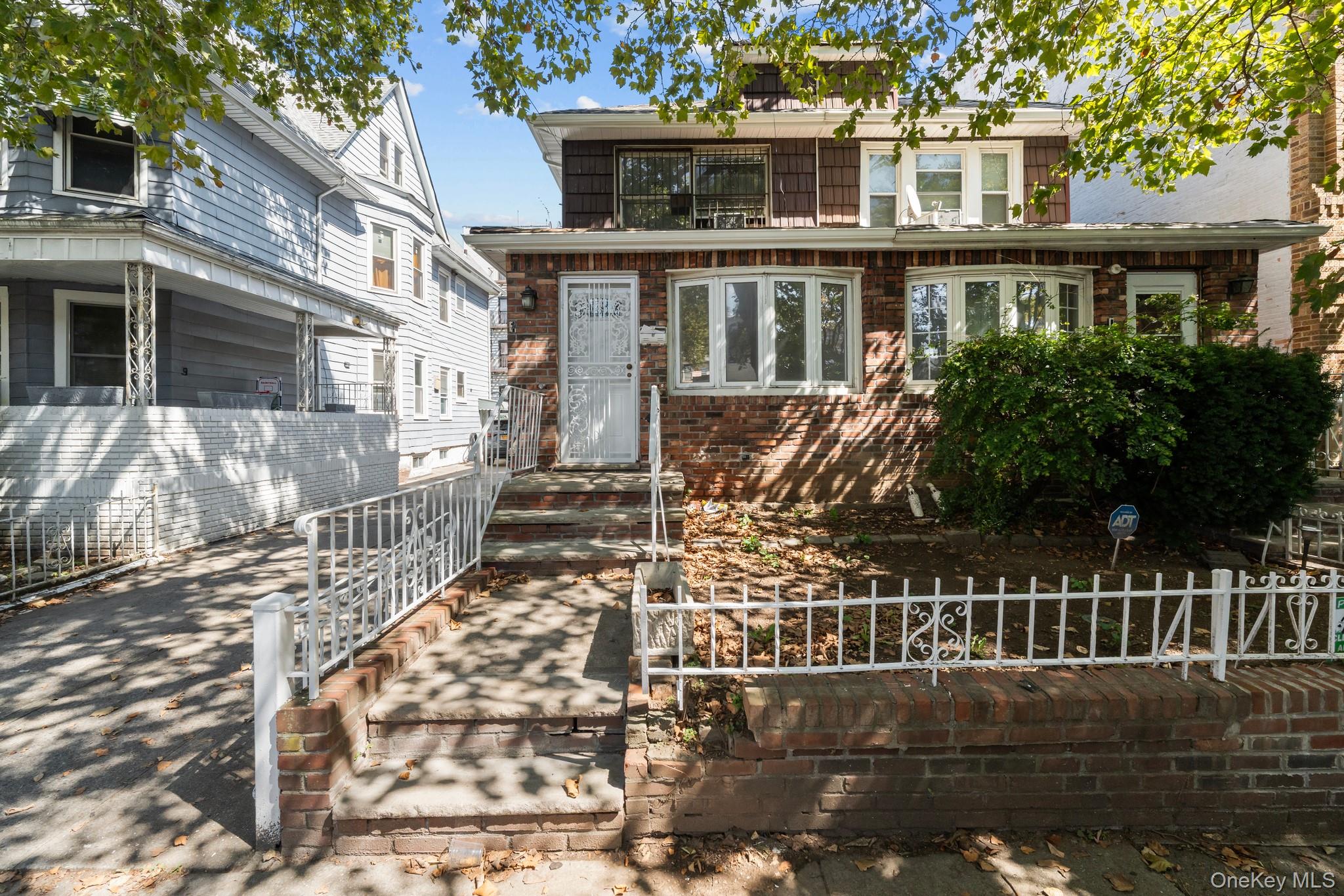 1069 East 35th Street Brooklyn, NY 11210 - Photo 16 of 16 Traditional style home with a fenced front yard and brick siding