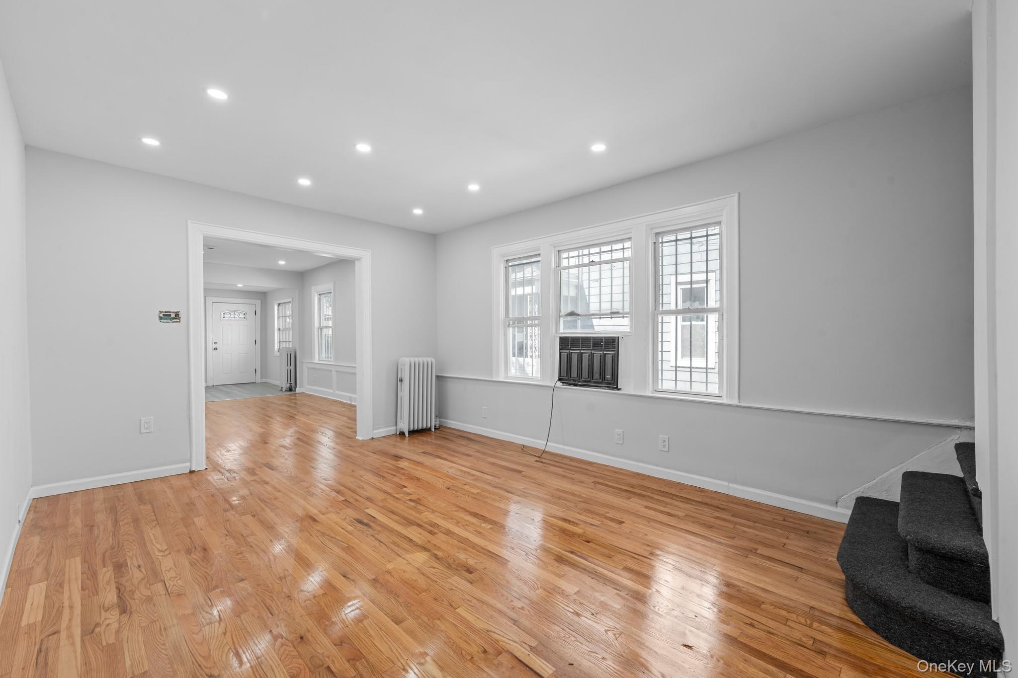 1069 East 35th Street Brooklyn, NY 11210 - Photo 5 of 16 Unfurnished living room with recessed lighting, light wood-style floors, and radiator