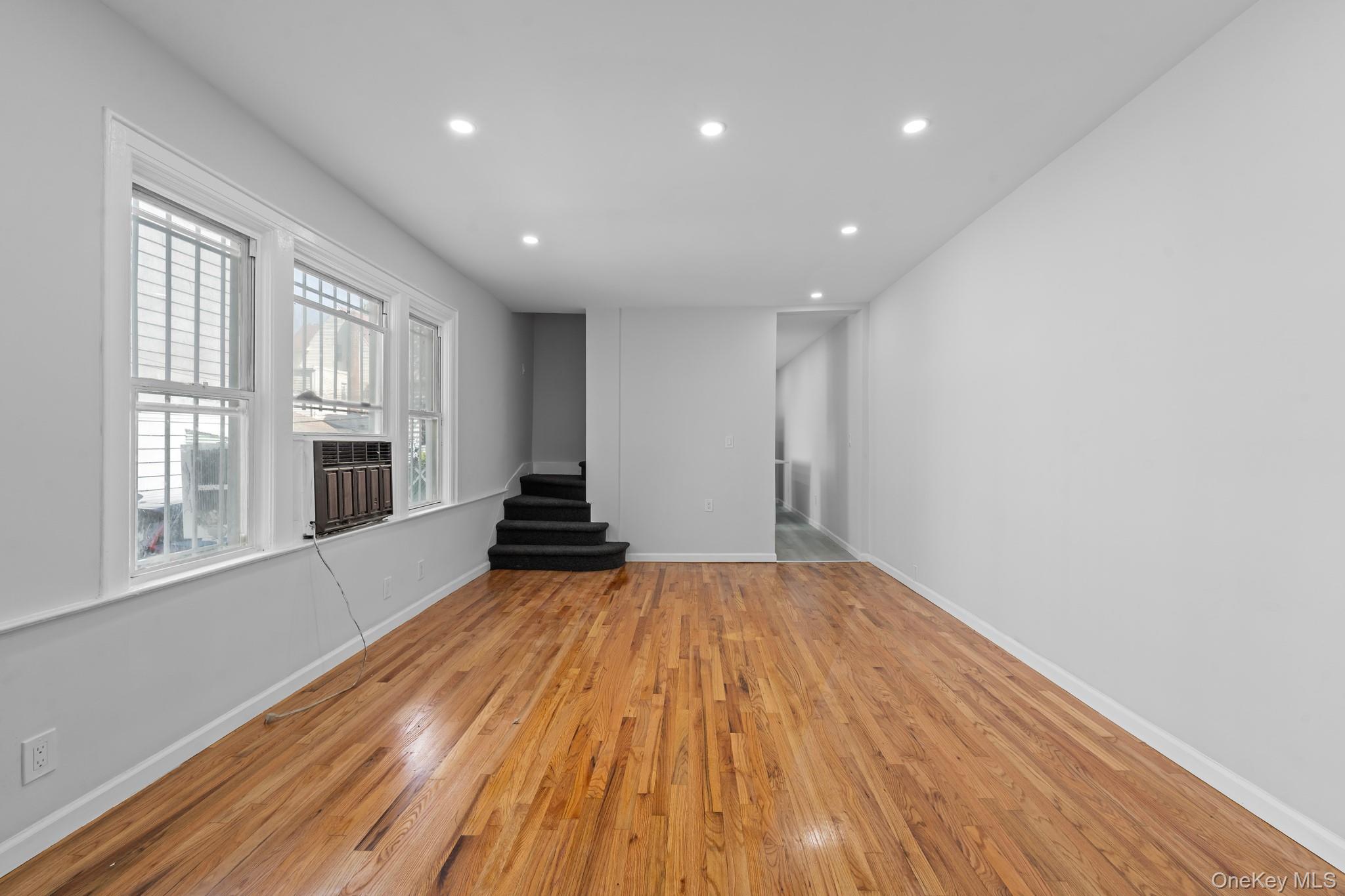 1069 East 35th Street Brooklyn, NY 11210 - Photo 6 of 16 Empty room featuring recessed lighting, light wood finished floors, and stairs