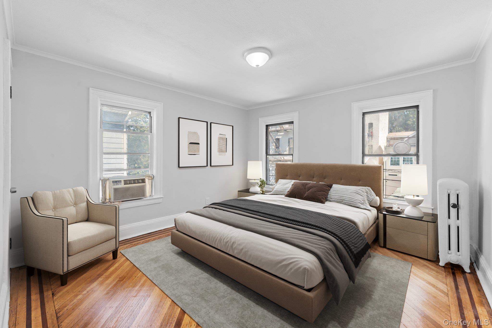 1069 East 35th Street Brooklyn, NY 11210 - Photo 7 of 16 Bedroom with radiator, ornamental molding, wood finished floors, and multiple windows