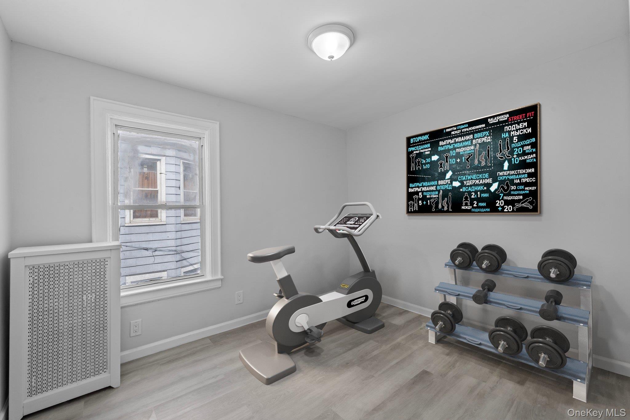 1069 East 35th Street Brooklyn, NY 11210 - Photo 9 of 16 Workout room featuring radiator heating unit and light wood-type flooring