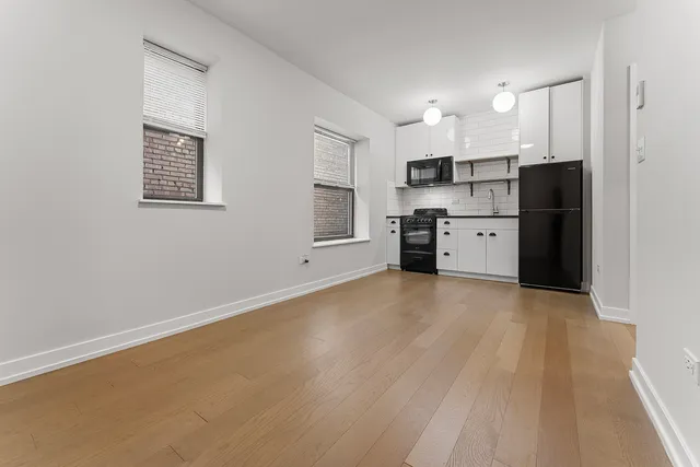 a view of kitchen with refrigerator cabinets and wooden floor