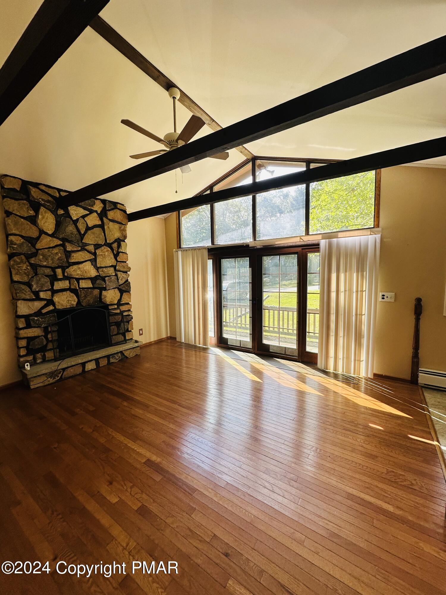 155 Sunrise Drive Milford, PA 18337 - Photo 7 of 16 an empty room with wooden floor and windows with curtains