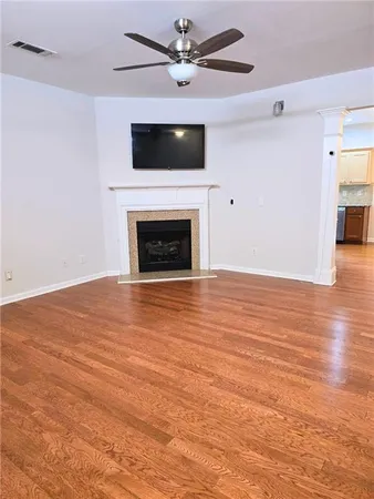 an empty room with wooden floor a fireplace and a window