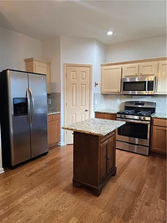 a kitchen with stainless steel appliances granite countertop a stove a refrigerator and a microwave