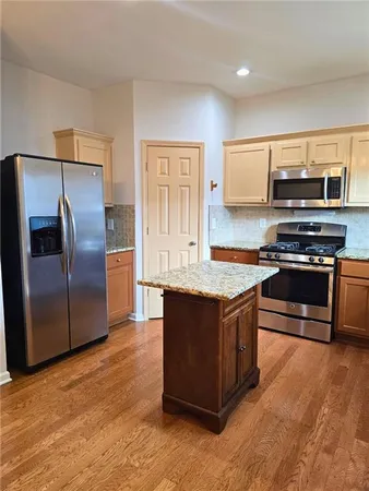 a kitchen with stainless steel appliances granite countertop a stove a refrigerator and a microwave