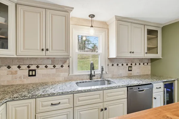 a kitchen with granite countertop white cabinets and a sink